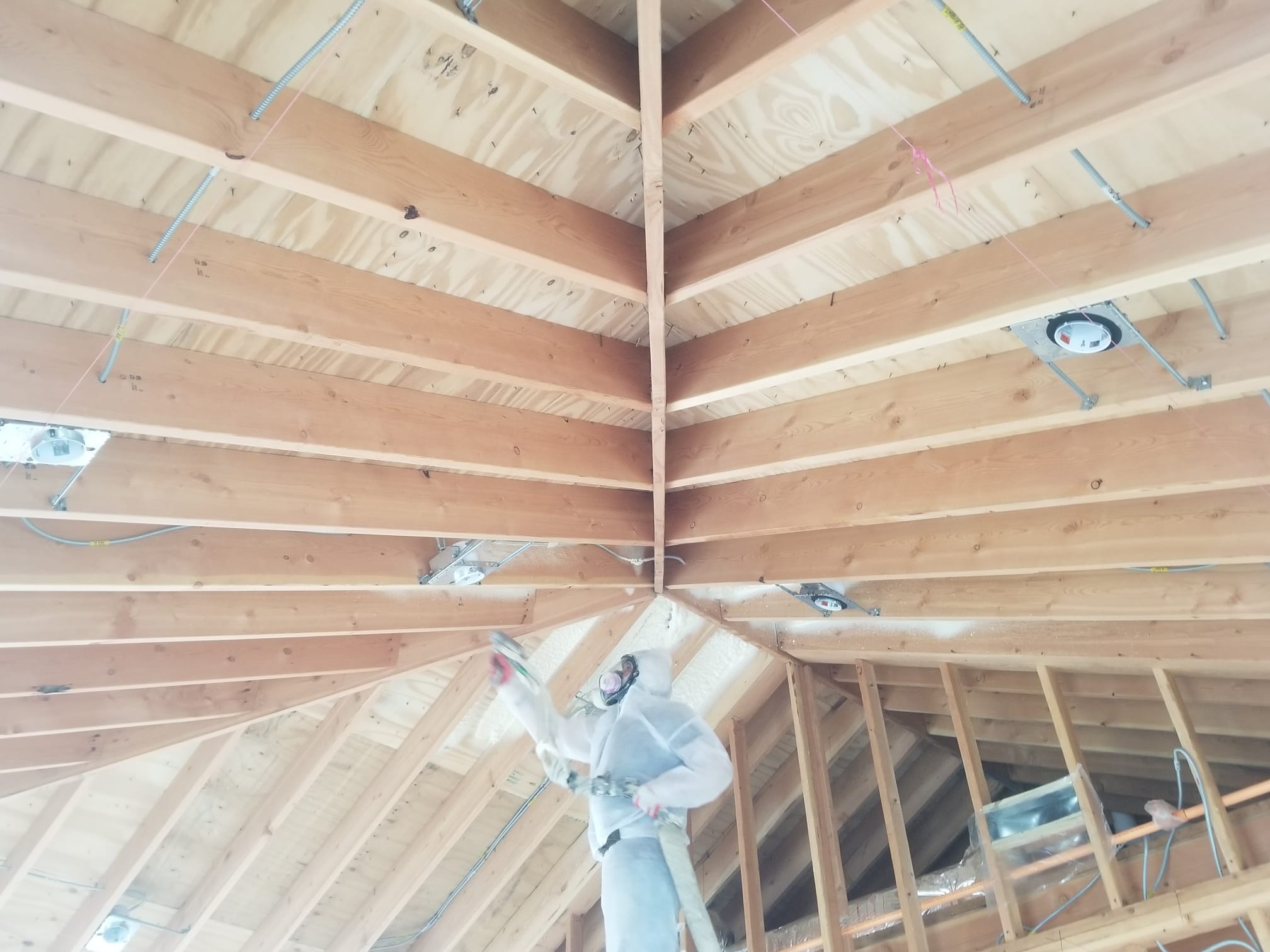 Spraying foam on a vaulted roof frame