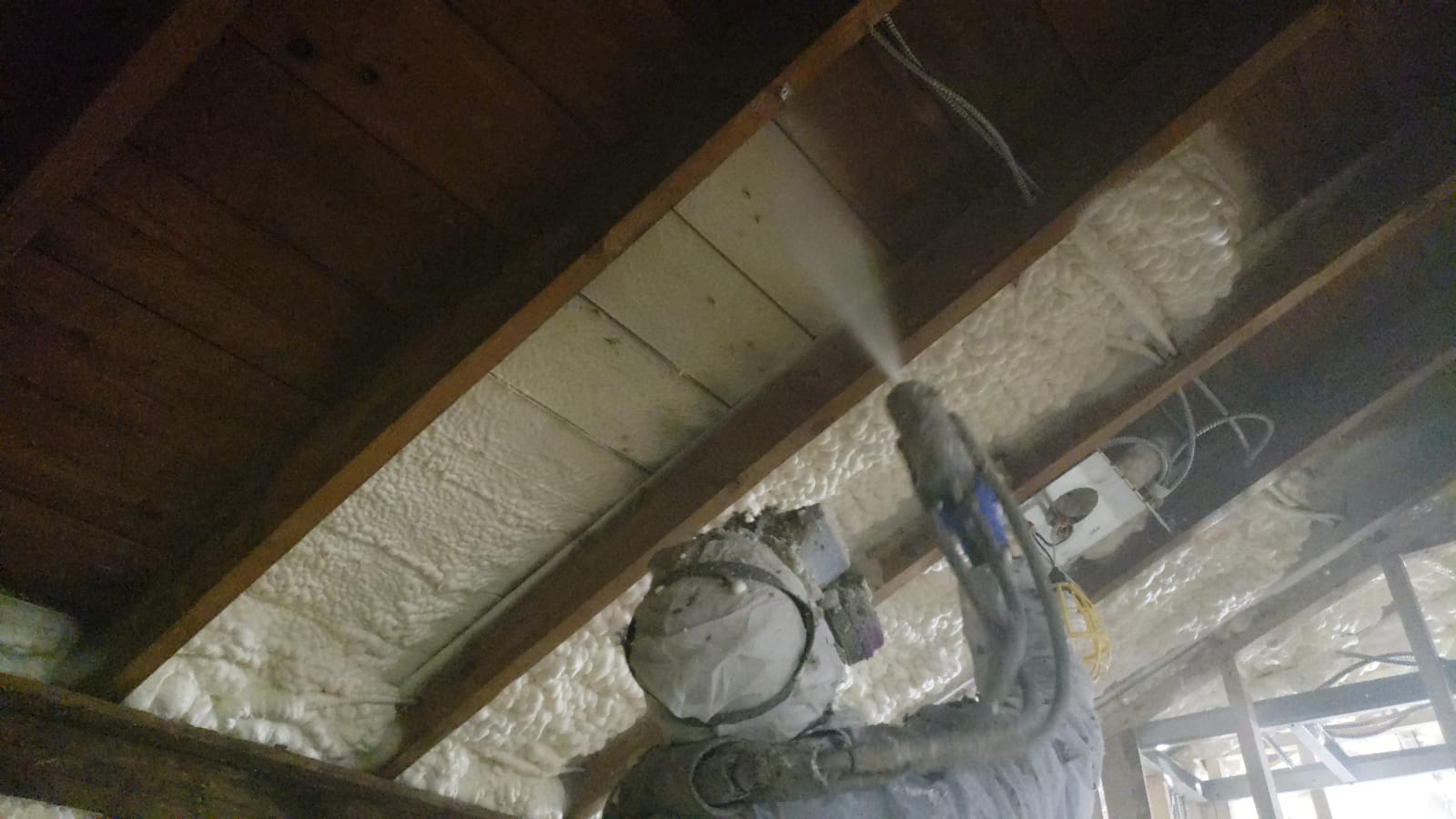 Spraying foam between ceiling joists